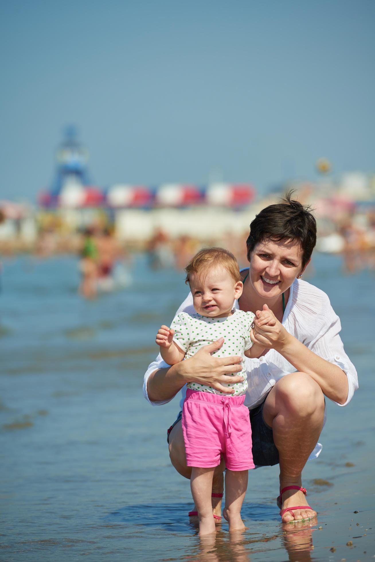 mom and baby on beach have fun Stock Free