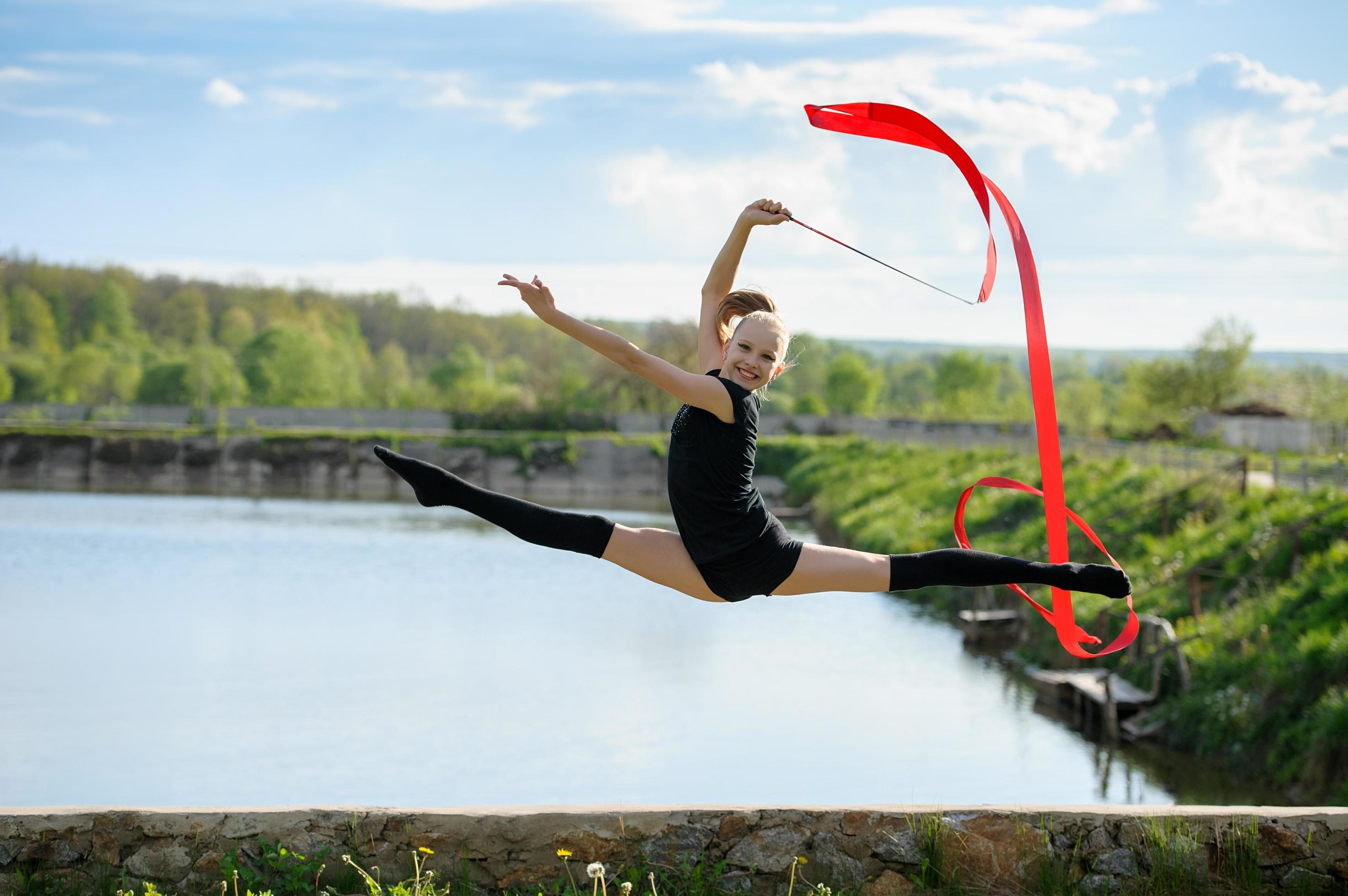 Gymnast leaping in the air with a ribbon Stock Free