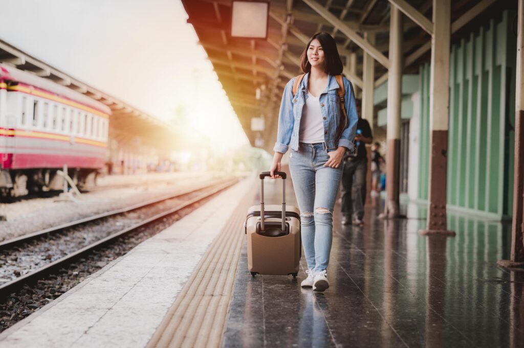 Woman with luggage at train station Stock Free