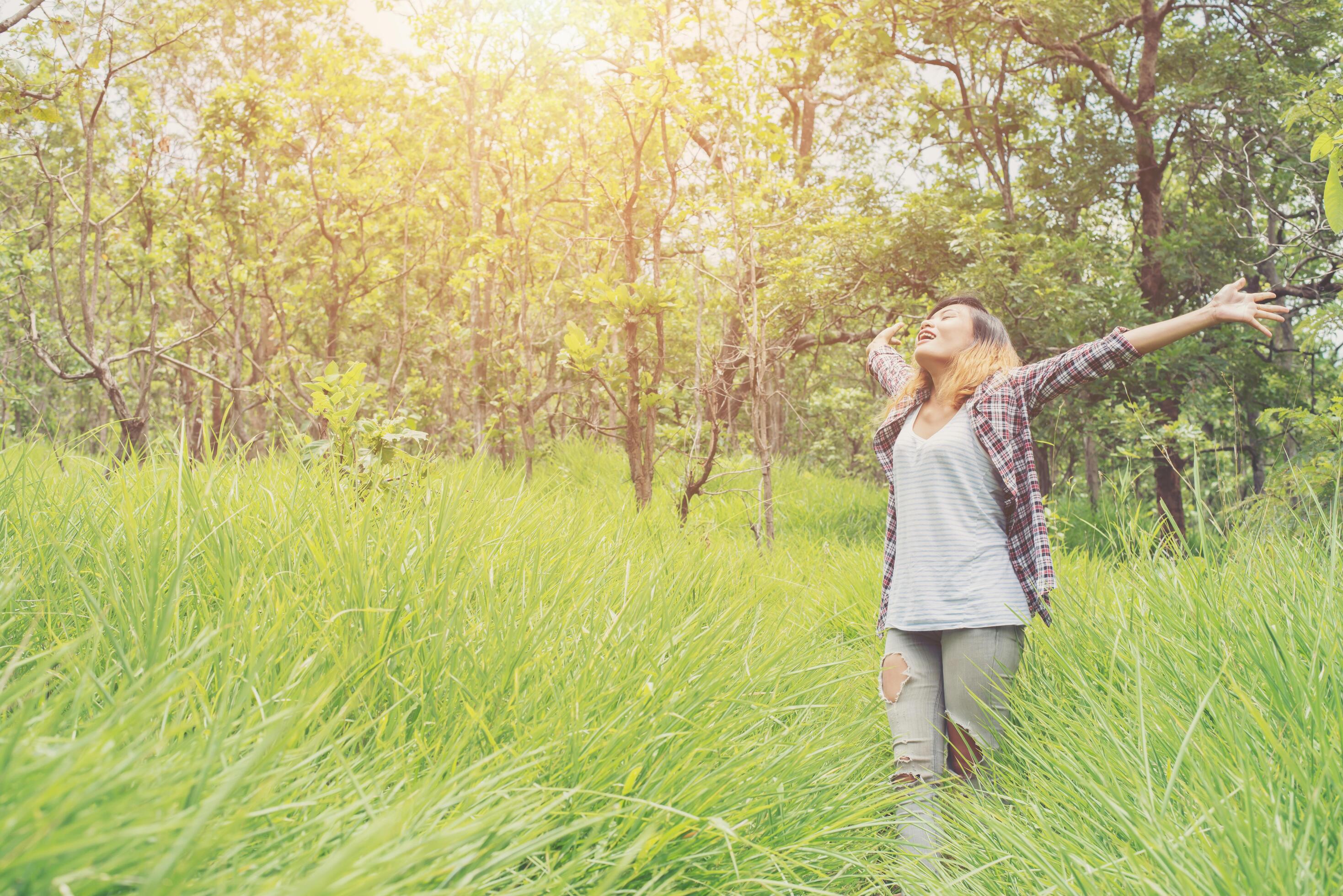 Freedom hipster woman raising hands in the air,enjoying with nature. Stock Free