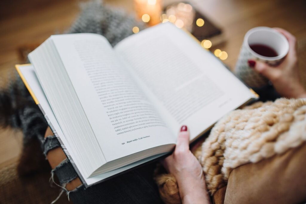 Woman drinking tea and reading book Stock Free