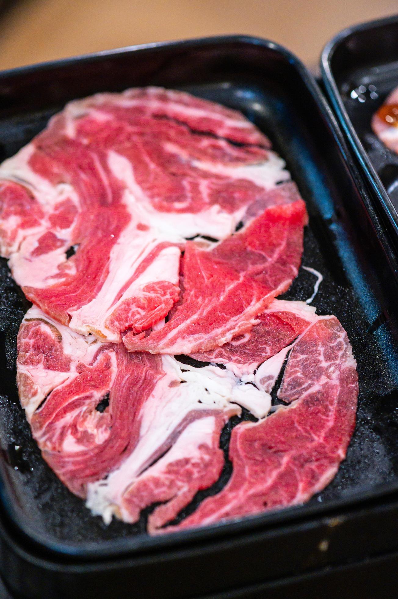 Slide raw beef for Yakiniku. Thin piece beef for Shabu hotpot japanese food style. Close up fresh meat chuck eye for Sukiyaki. top view Stock Free