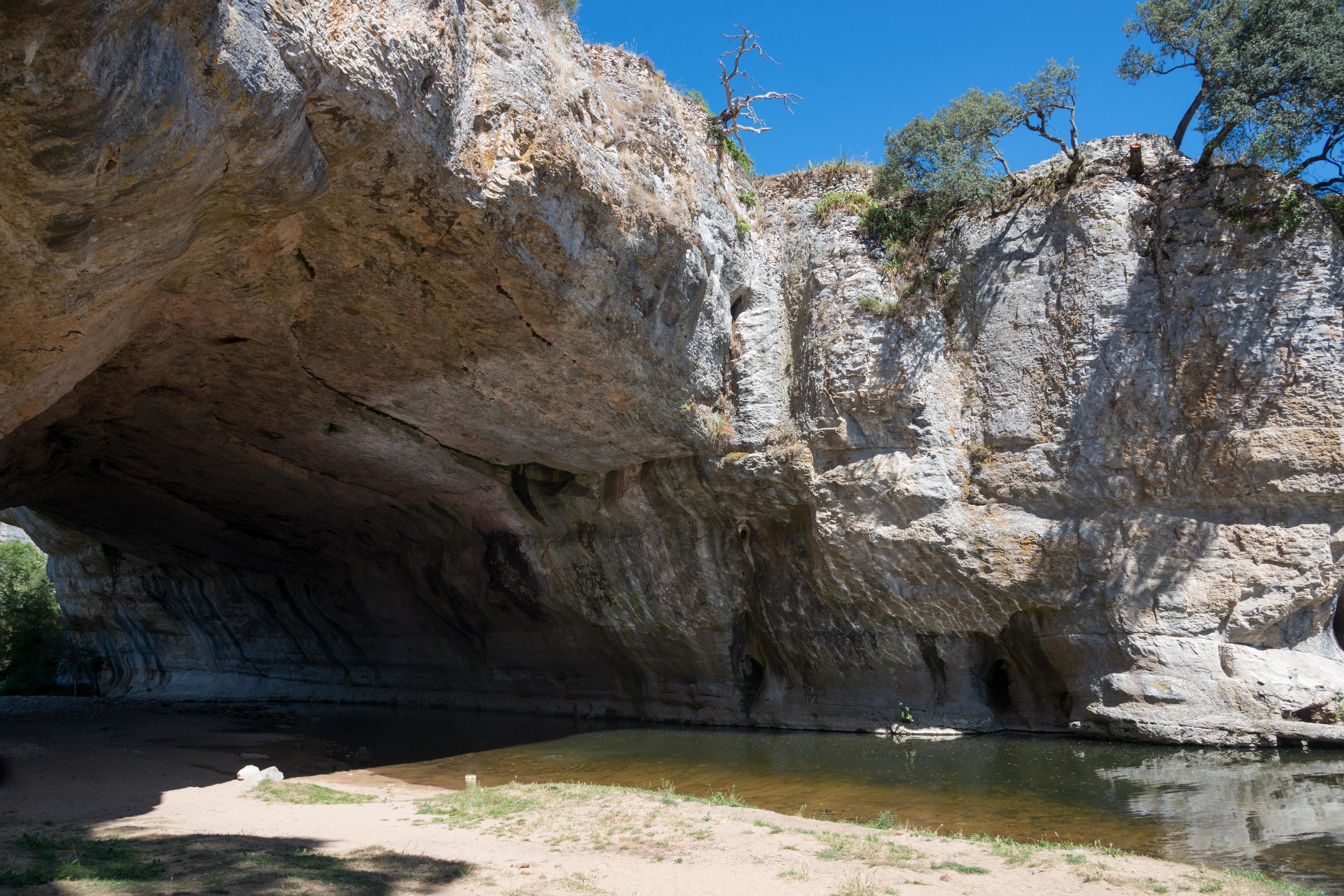 Natural bridge of rock over the river at Puentedey. Bathing area. Merindades, Burgos, Spain Stock Free