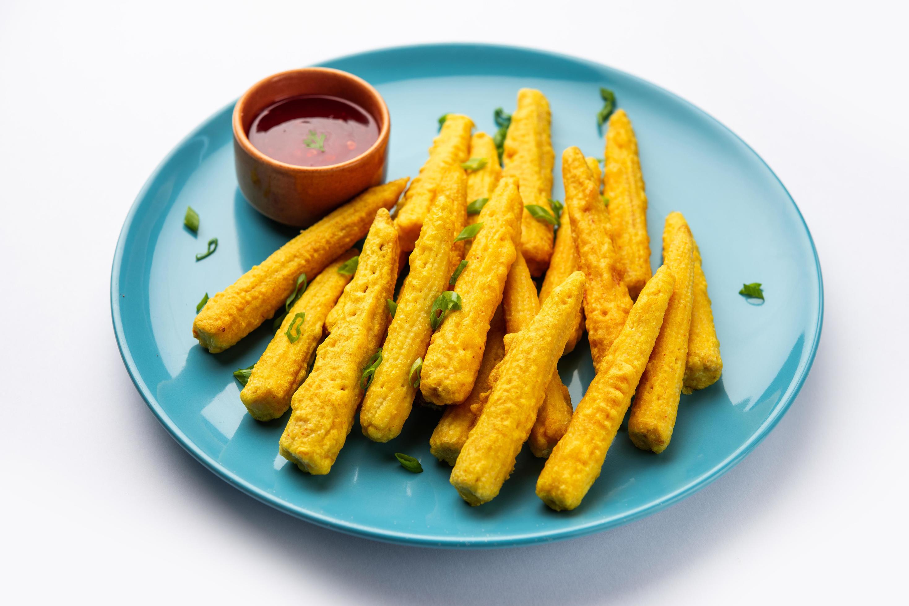 Crispy fried baby corn pakoda, pakora or Baby corn fritters served with ketchup, Indian food Stock Free