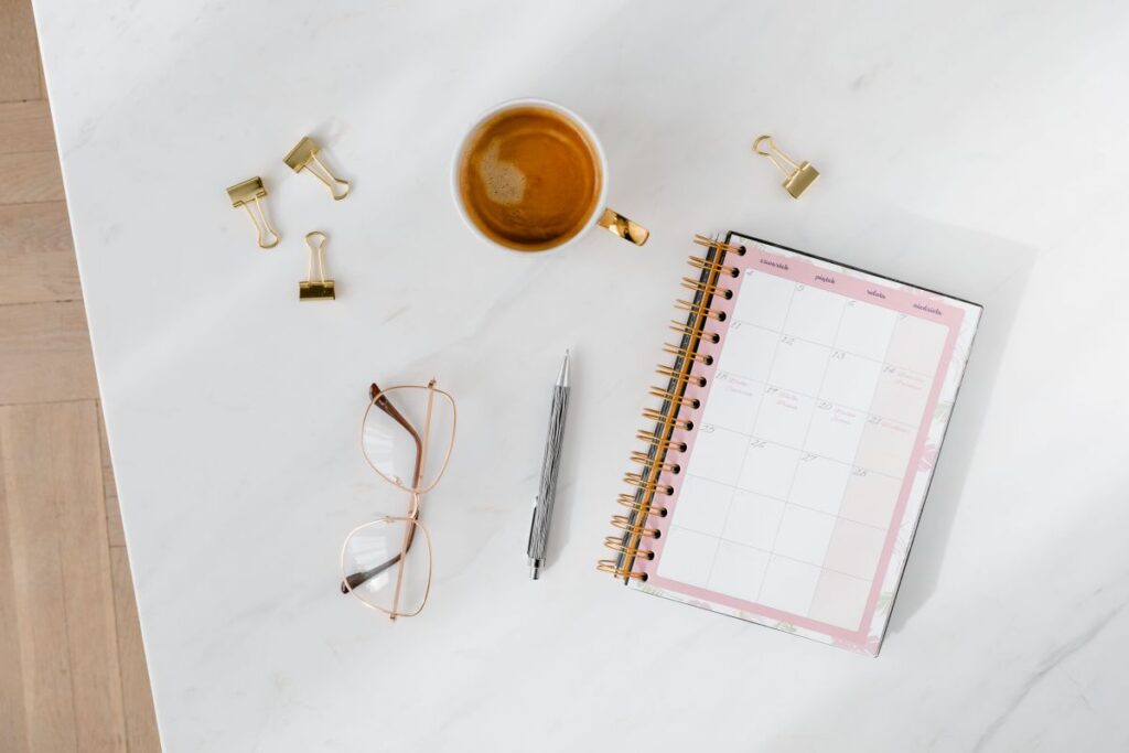 Top view of a marble desk with coffee, notebooks and pen Stock Free