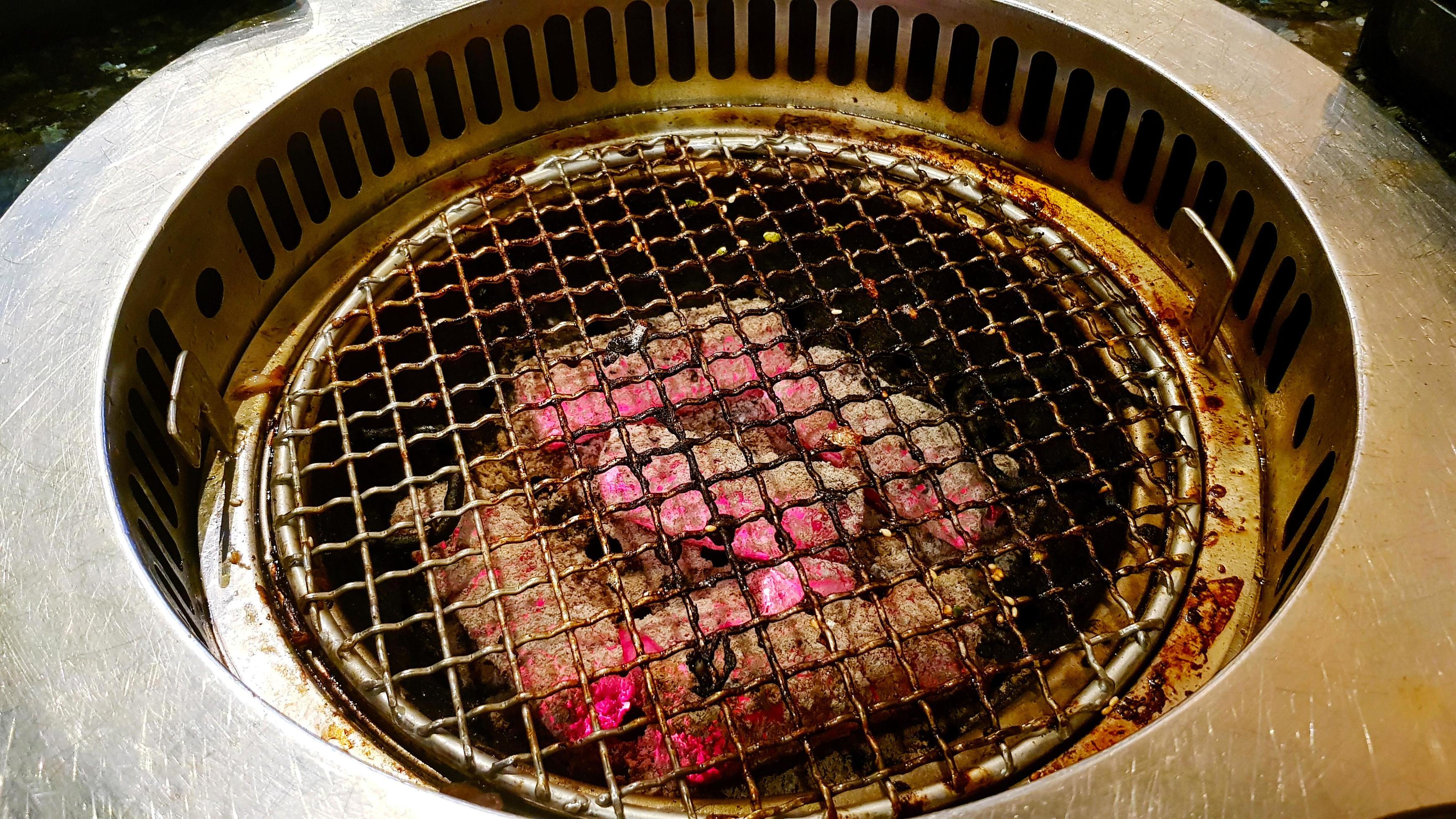 Charcoal grill stove with stainless steel net for barbecuing in Korean restaurants. Equipment for cooking or making food. Stock Free