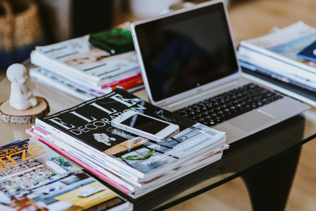 Laptop, a smartphone, magazines and cups of coffee on a table Stock Free