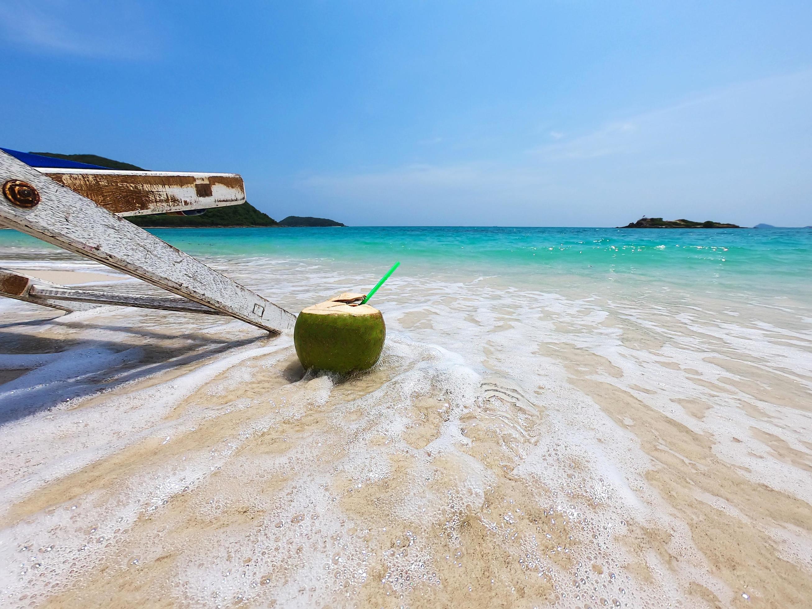 Relax beach chair with fresh coconut on clean sand beach with blue sea and clear sky – sea nature background relax concept Stock Free