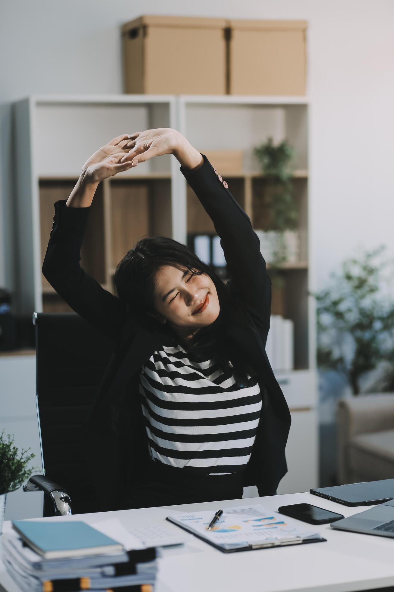 Office asian business woman stretching body for relaxing while working with laptop computer at her desk, office lifestyle, business situation Stock Free