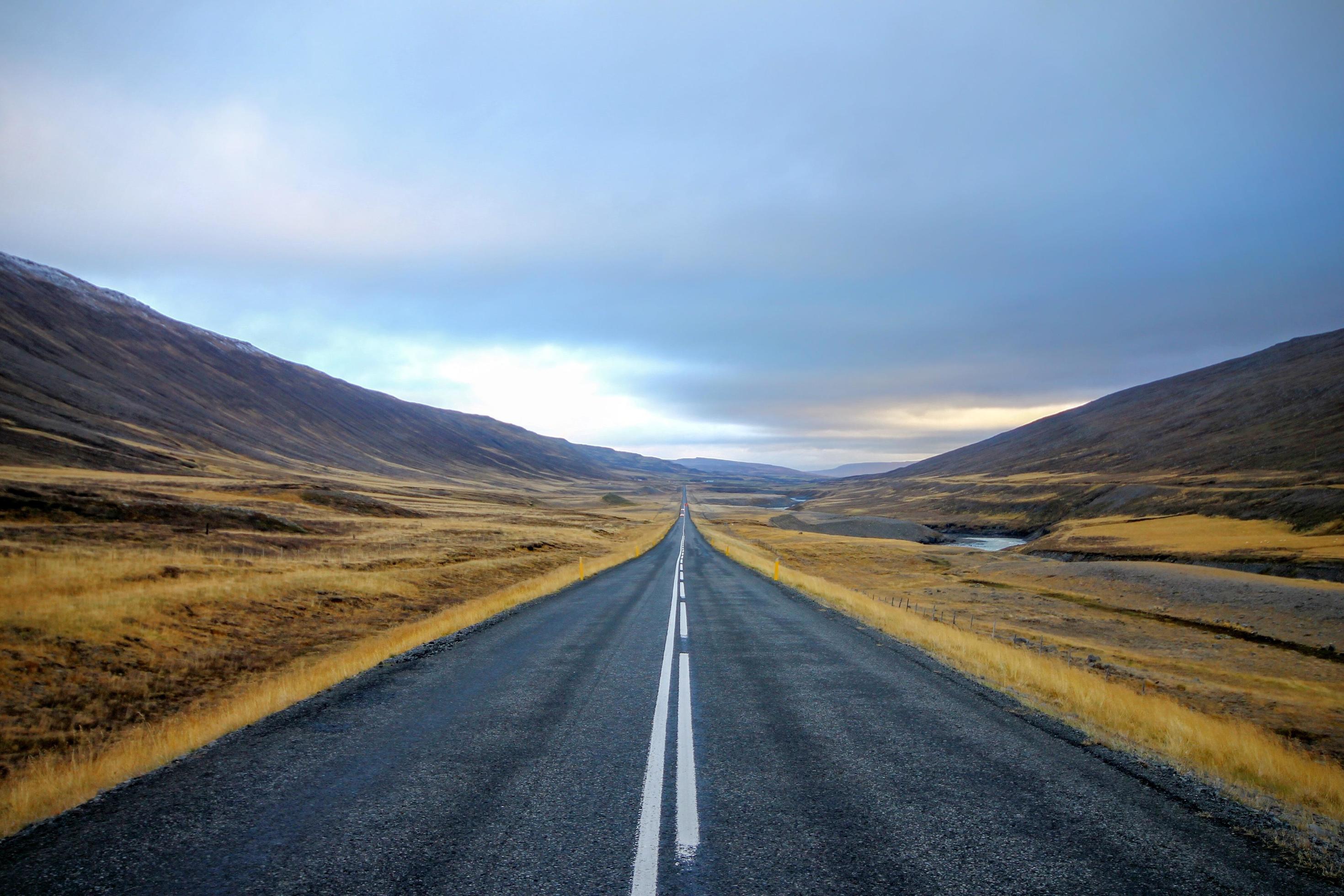 Road running through a hilly landscape Stock Free