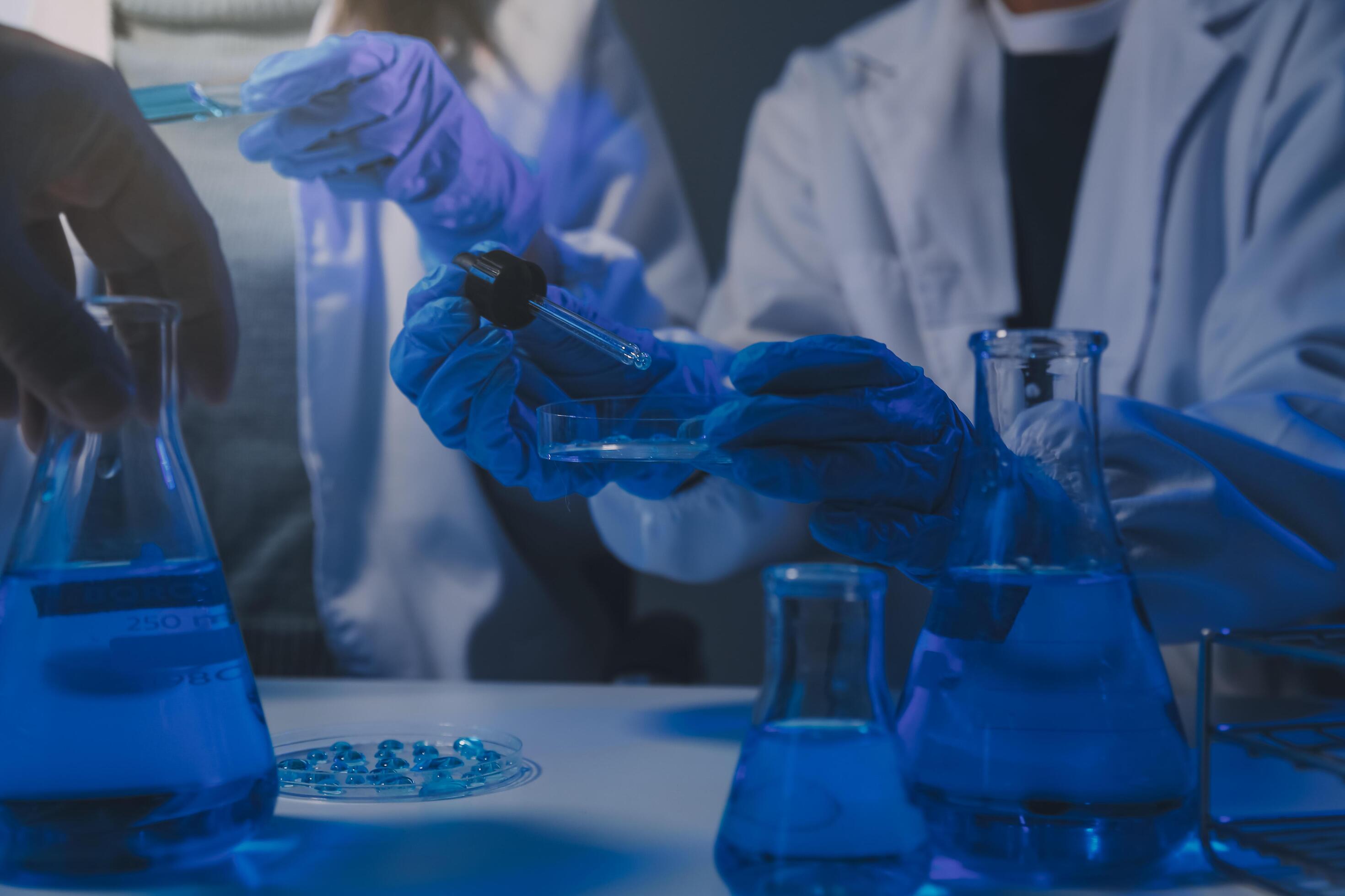 chemist,scientist hand dropping chemical liquid into test tube, science research and development concept Stock Free