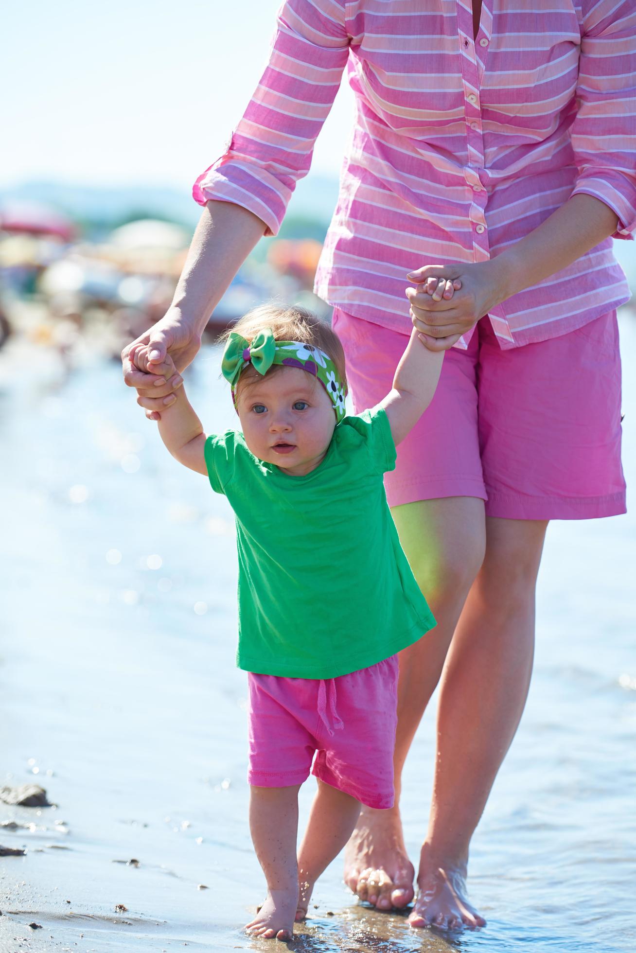 mom and baby on beach have fun Stock Free