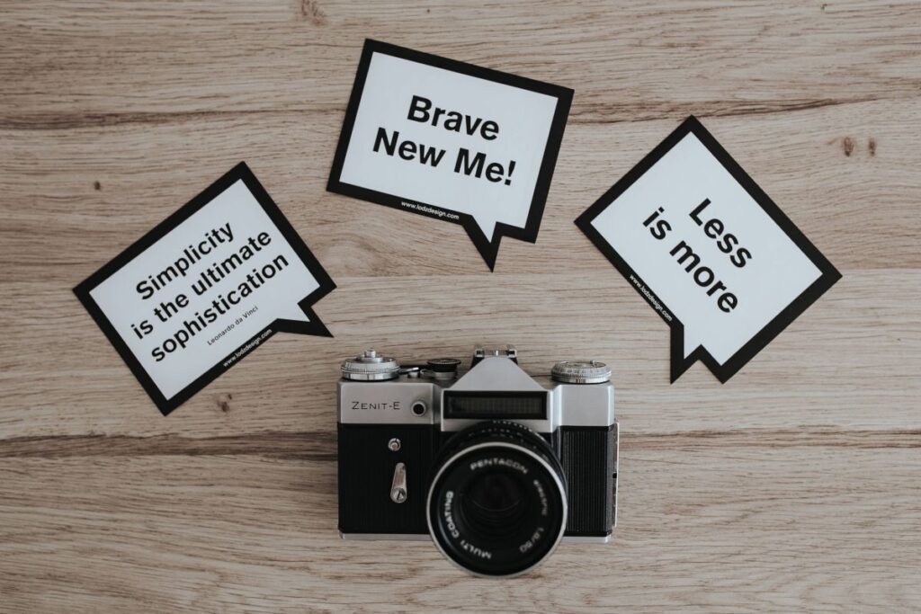 Little cards with inspirational quotes and a black camera Stock Free