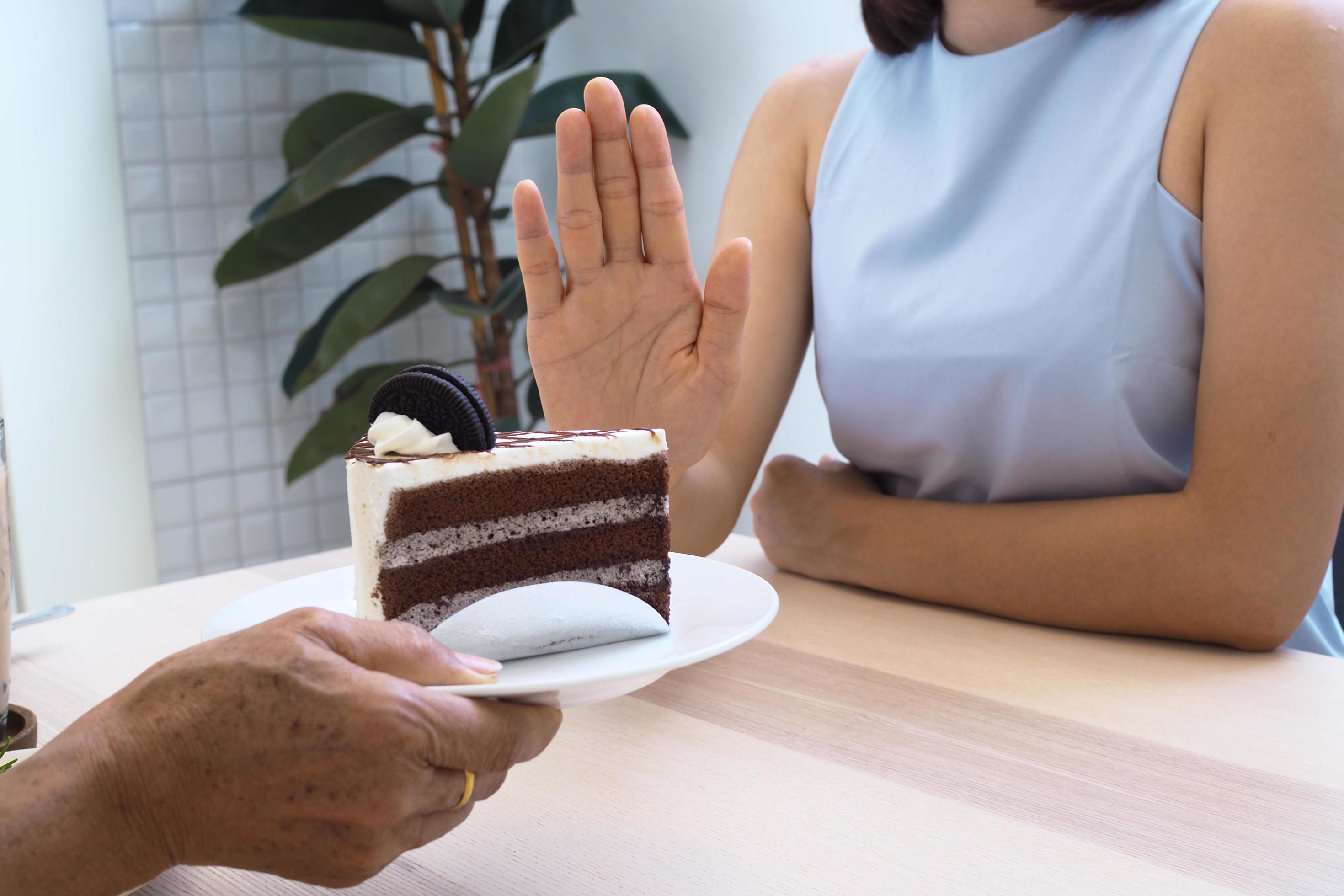 One of the health-care girls used a hand to push a plate of chocolate cake. Refuse to eat foods that contain Trans Fat. Stock Free