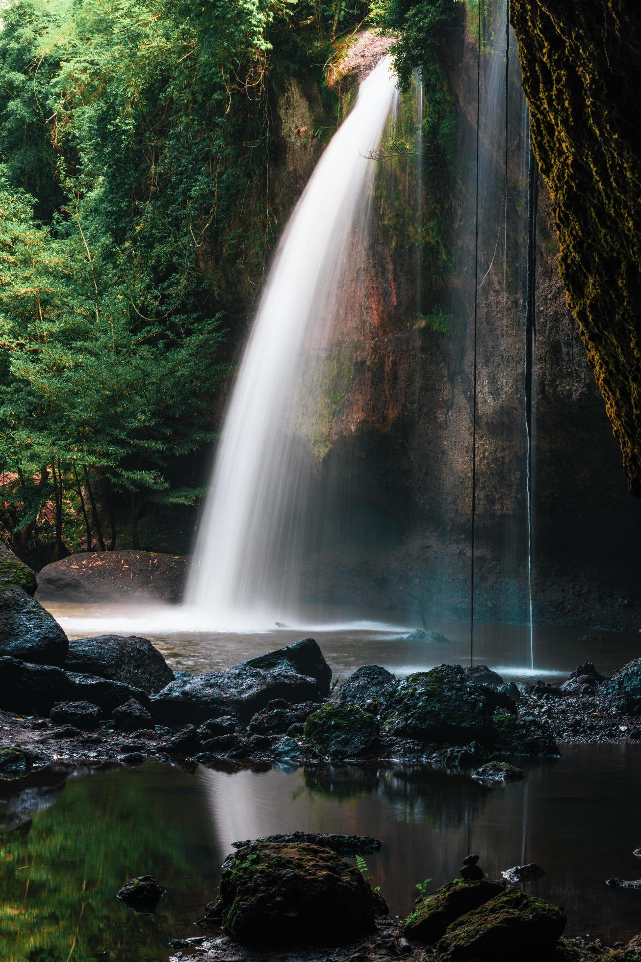 A natural waterfall in a big forest in the midst of beautiful nature. Stock Free