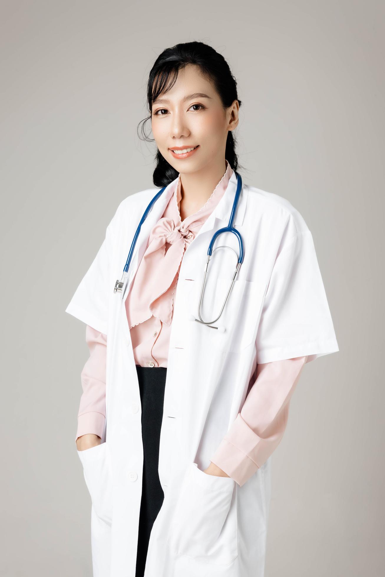 Portrait of an attractive young female doctor in white coat. Stock Free