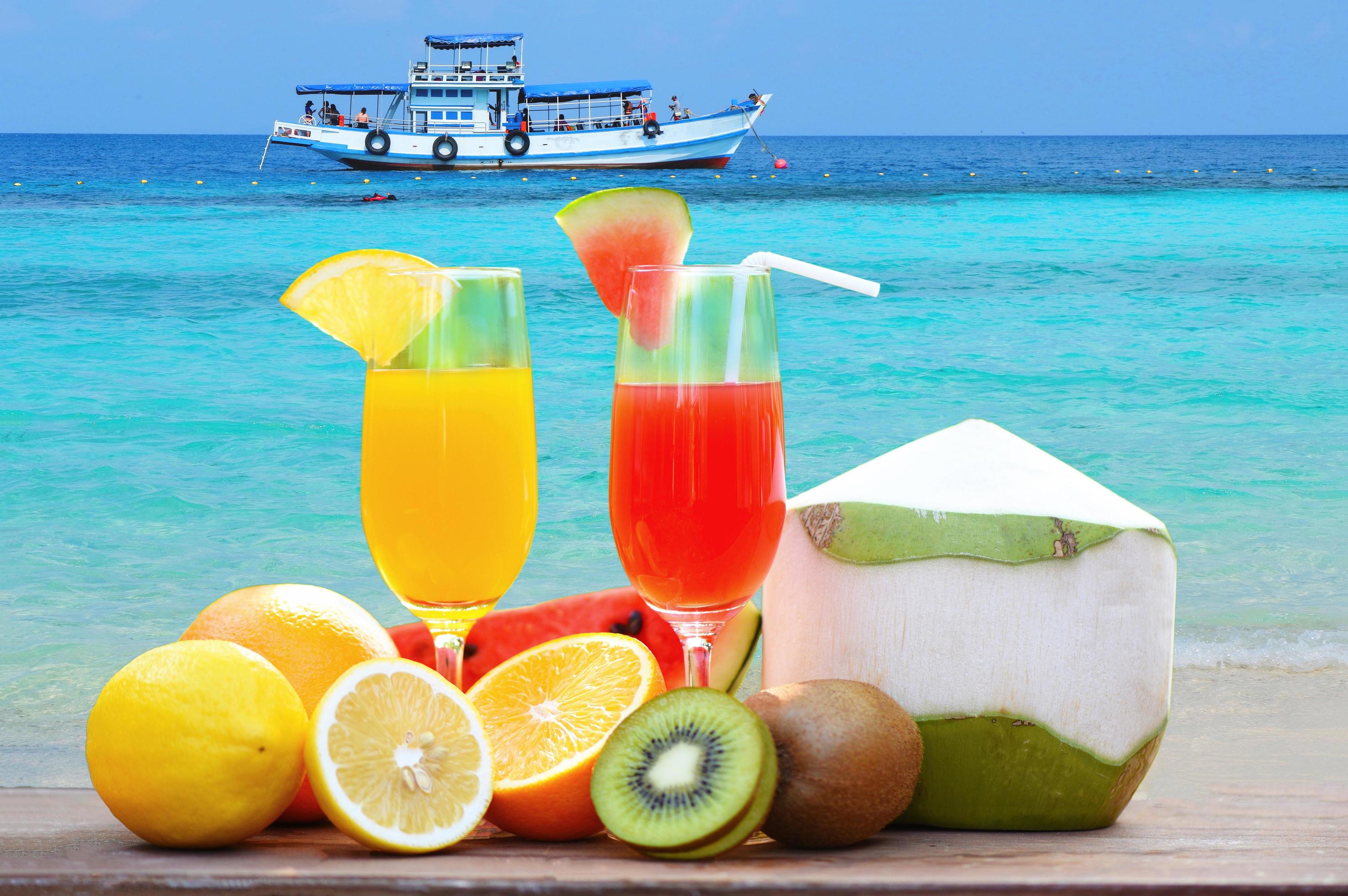 summer juice glass healthy foods Many ripe fruit mixed on the beach blue sea Stock Free