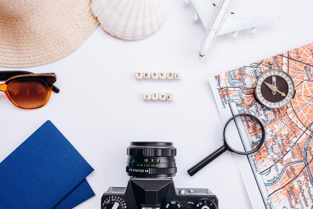 White background with things for travel passport, sunglasses, magnifying glass, hood, compass, seashell Stock Free