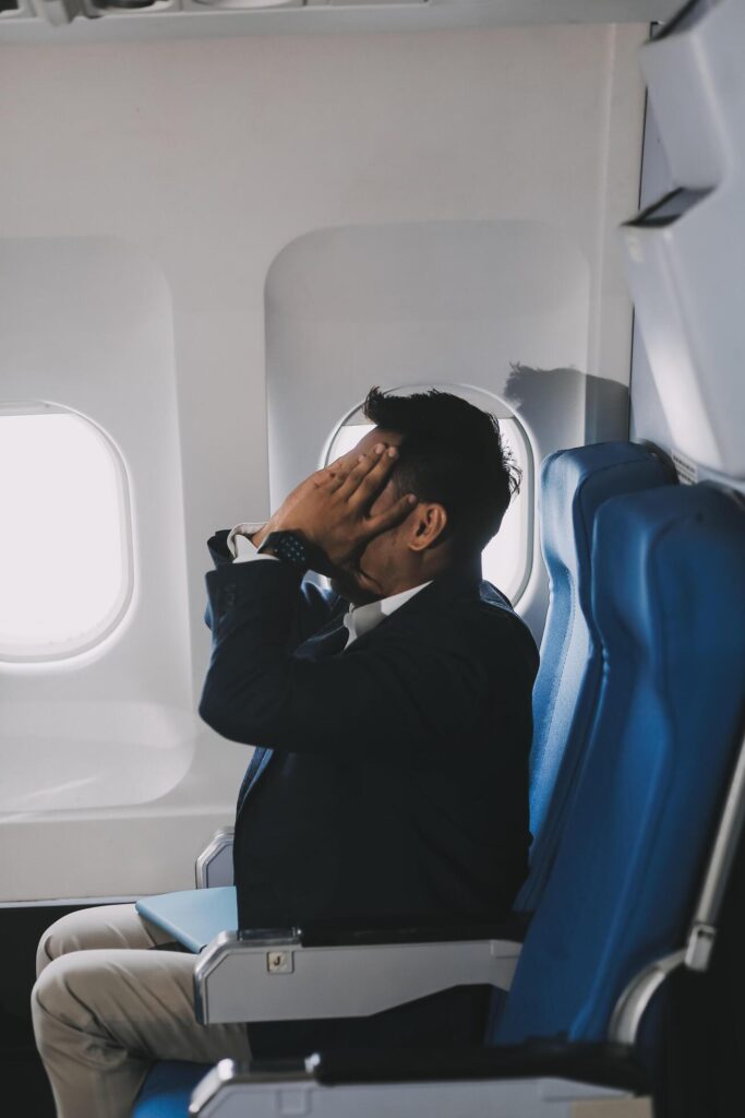 Business Man Having Headache Pain or Frustration Problem in Interior of an Airplane, Corporate Airline Travel Concept Stock Free