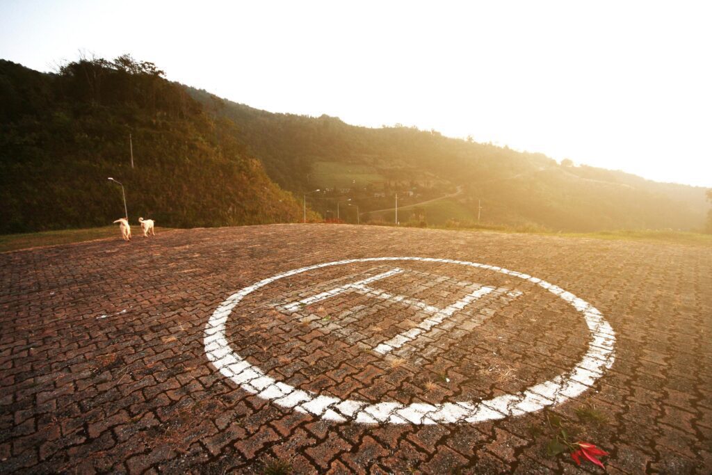 Helicopter landing symbol on concrete floor with natural sunset on the mountain. Stock Free