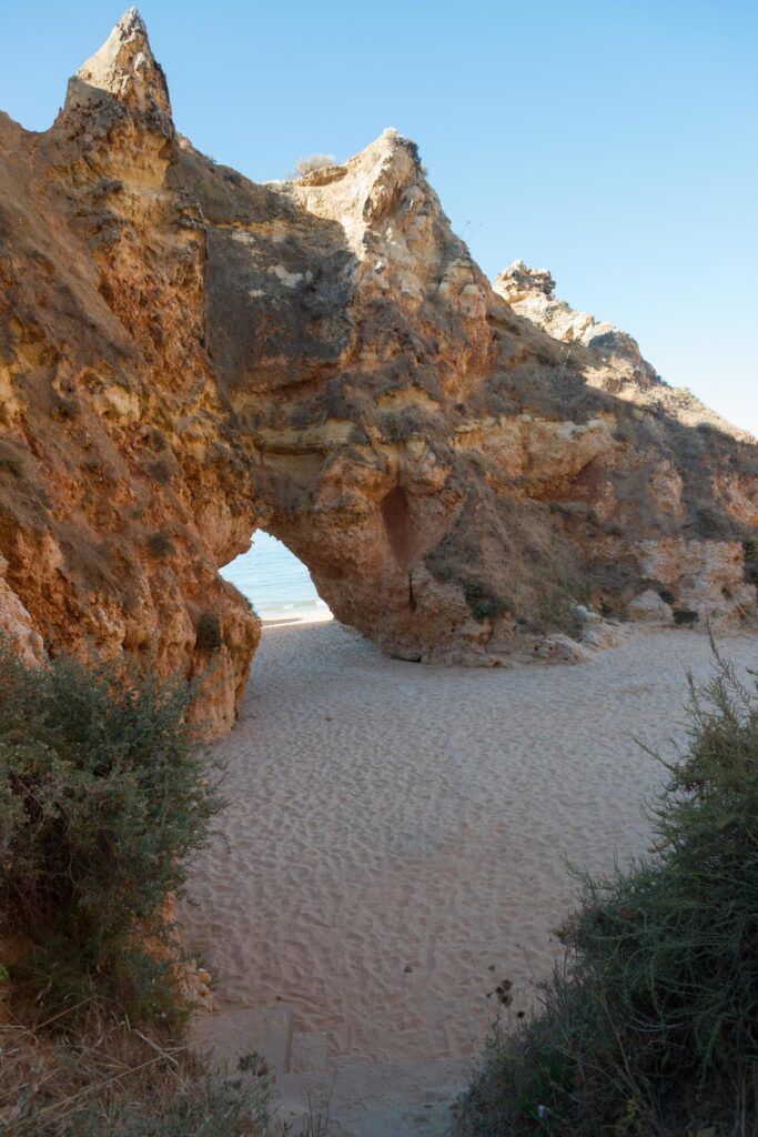 Beautiful natural arch to walk through at a beach in Algarve, Portugal. Stock Free