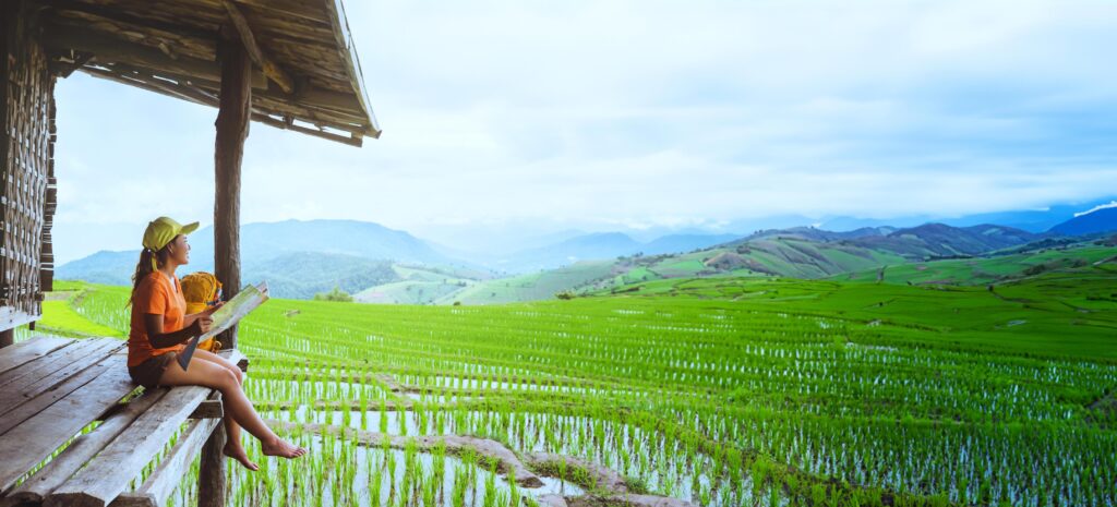 Asian woman travel nature. Travel relax. sit look map the balcony of the resort. View of the field on the Moutain in summer. Thailand Stock Free