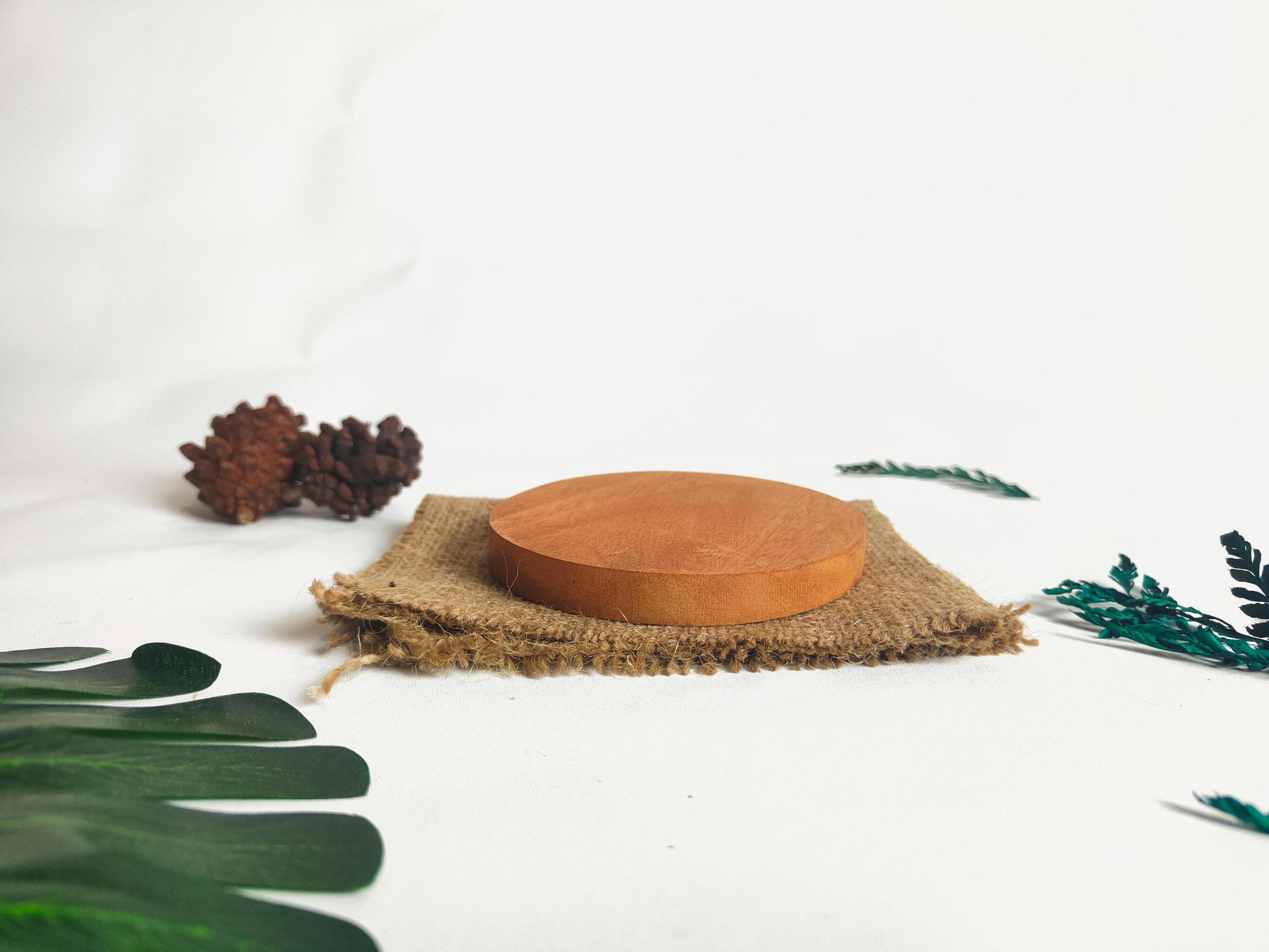 photography of circular wooden coasters with leaf ornaments on a white background suitable for mock-ups Stock Free