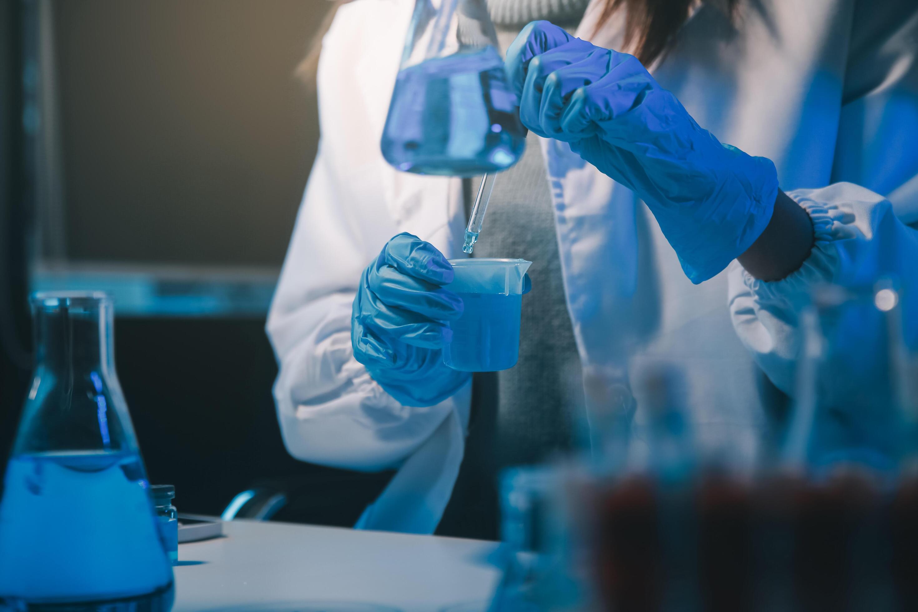 chemist,scientist hand dropping chemical liquid into test tube, science research and development concept Stock Free