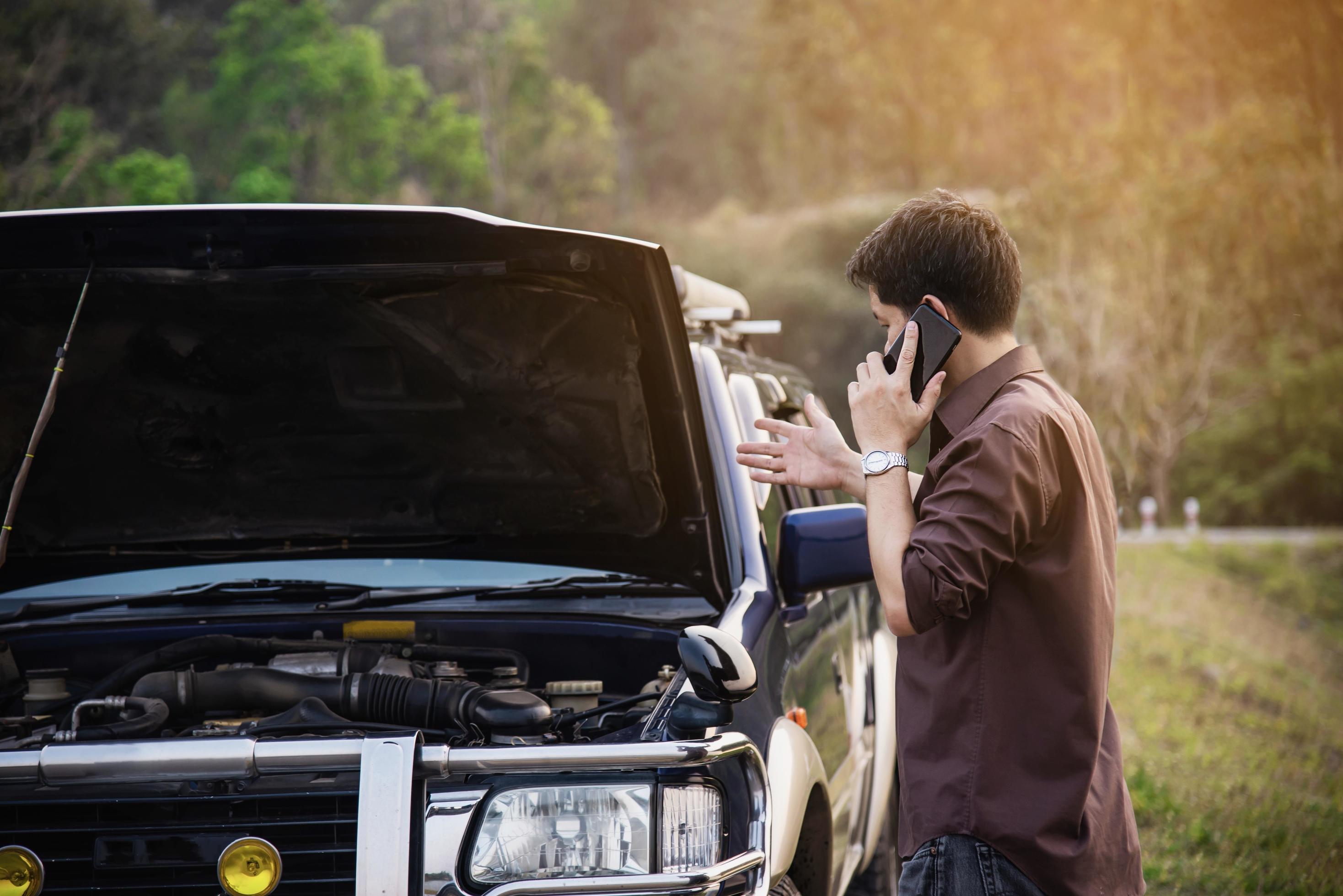 Man try to fix a car engine problem on a local road Chiang mai Thailand – people with car problem transportation concept Stock Free