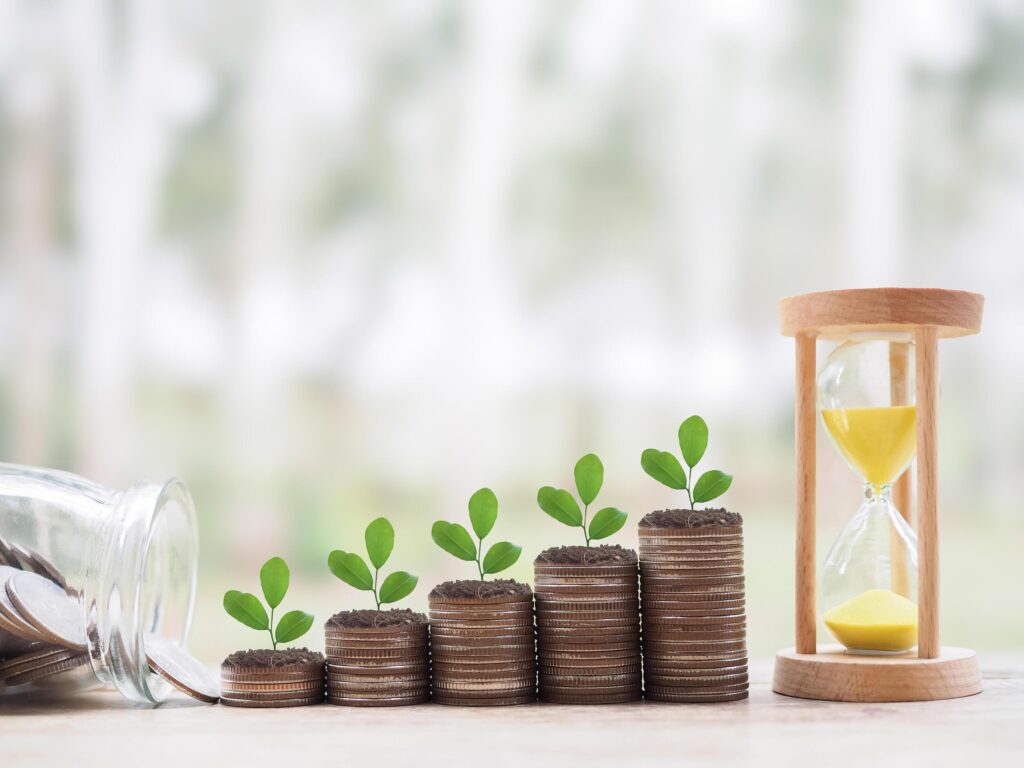 Hourglass and plants growing up on stack of coins. The concept of saving money, manage time to success Financial, Investment and Business growing up. Stock Free