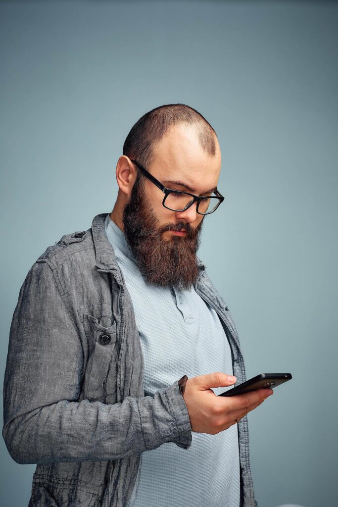 lifestyle brooding man with a beard and a telephone, background, copyspace. Stock Free