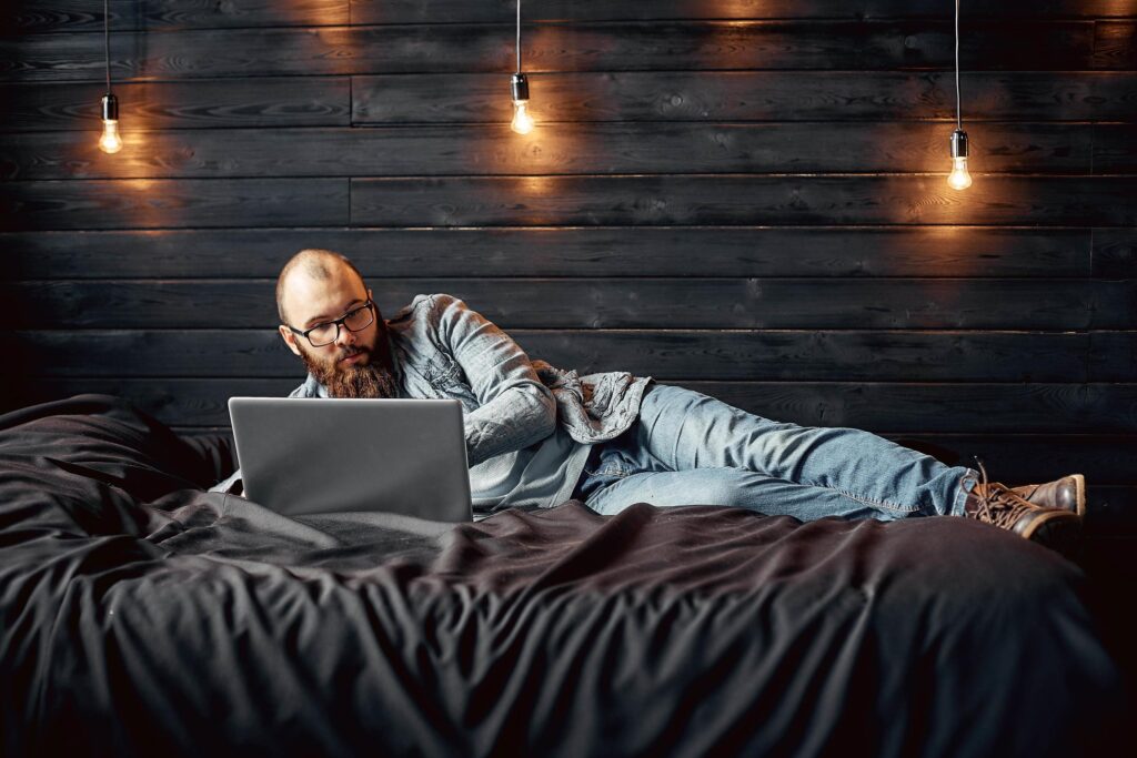 lifestyle successful freelancer man with beard achieves new goal with laptop in loft interior Stock Free