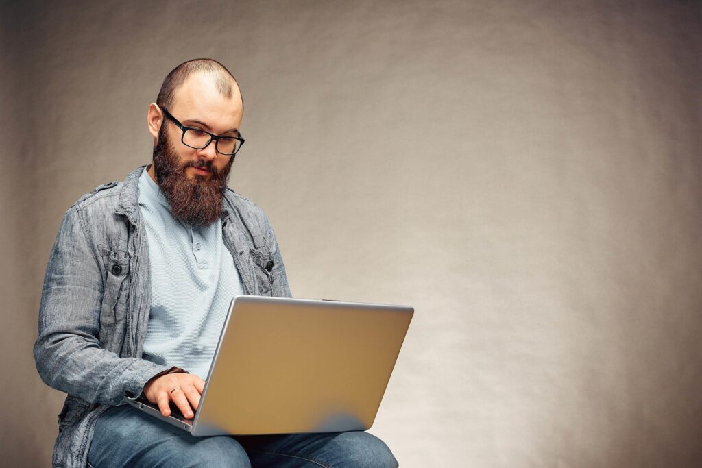 lifestyle successful freelancer man with beard achieves new goal with laptop in loft interior. Stock Free