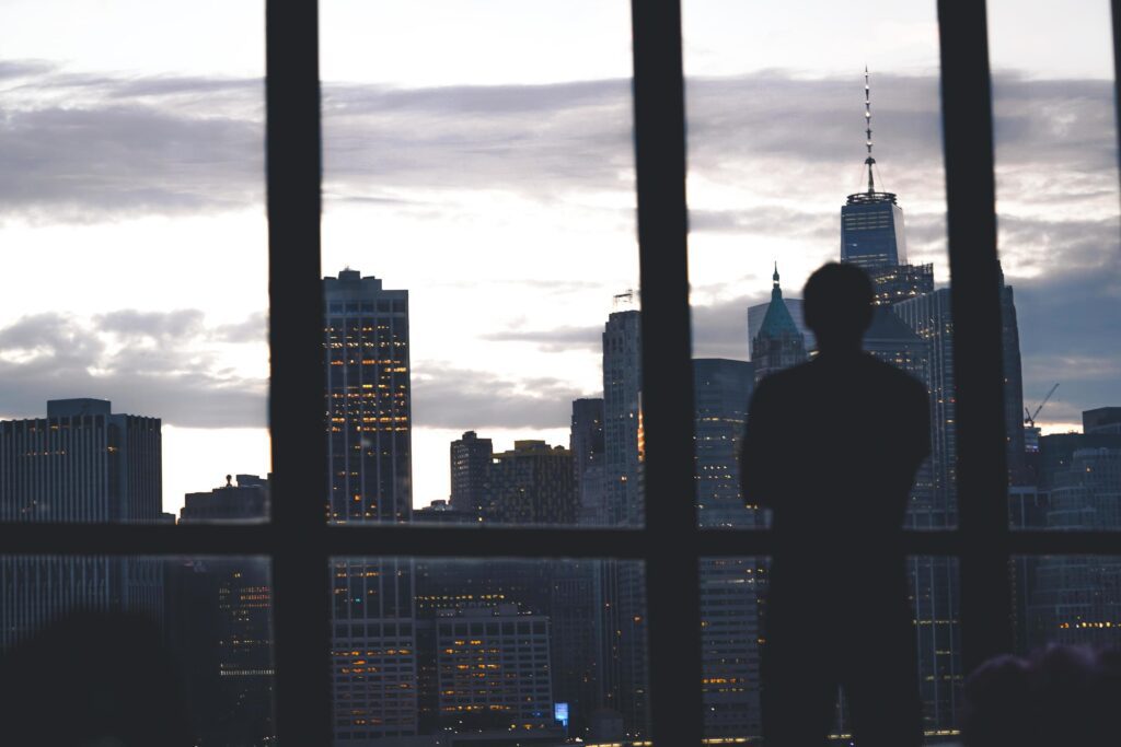 Man standing near city window Stock Free