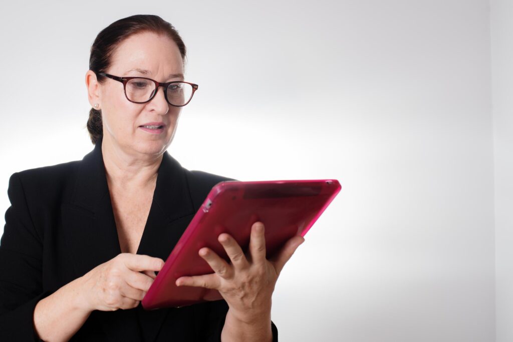 Mature business woman with glasses holding a digital tablet Stock Free