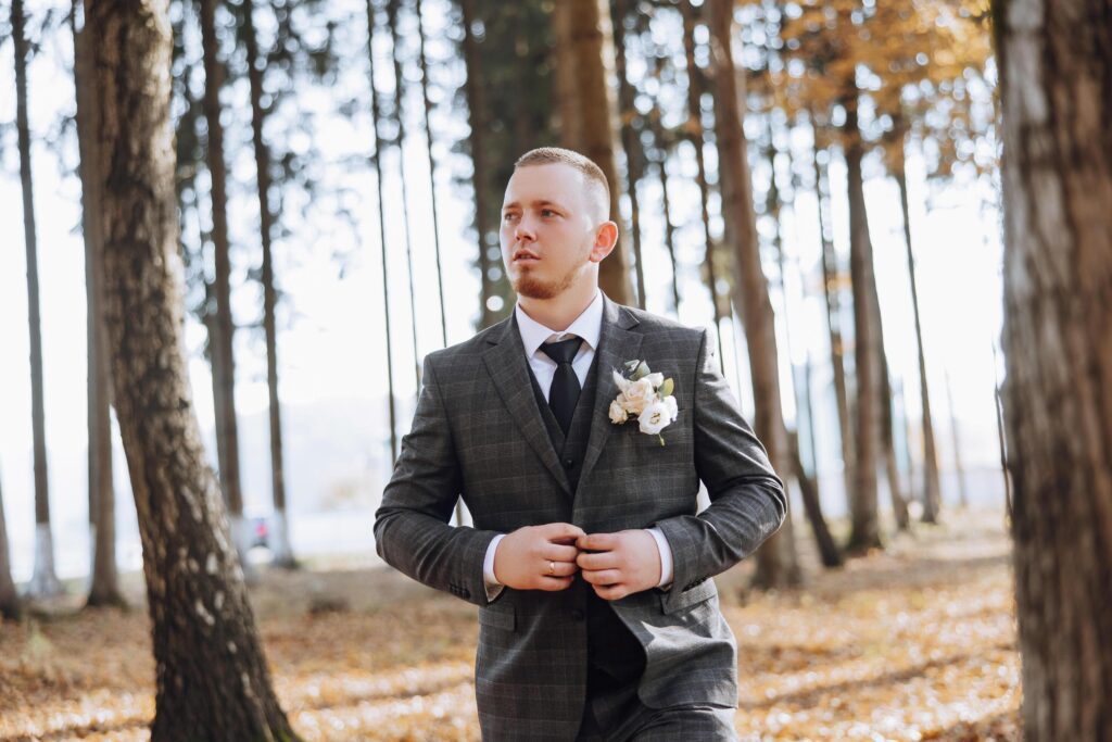 Portrait of a handsome young groom on an autumn day outdoors in an elegant suit. Outdoor photo. Handsome man in a business suit. Stock Free