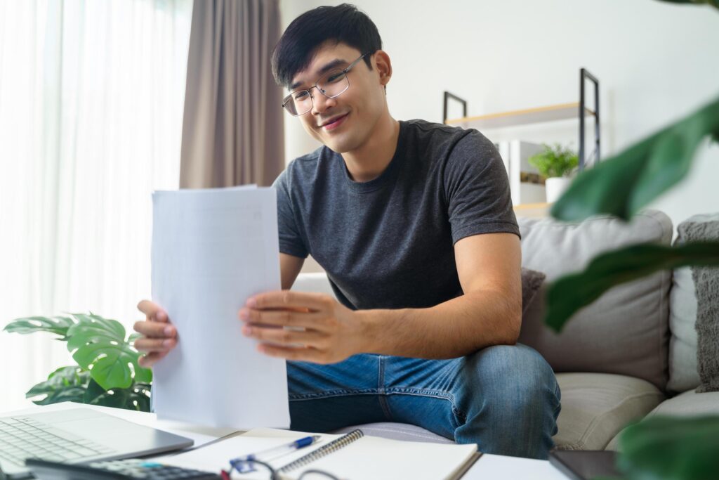 The happy man satisfied when he gets good news in paper, finishes work, makes a good business deal, job promotion, loan approval, great exam result Stock Free