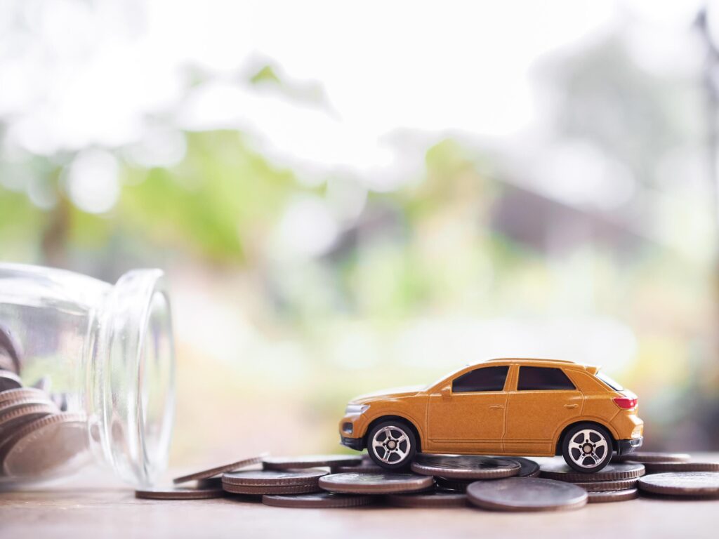 Toy car on stack of coins. The concept of saving money and manage to success transport business Stock Free