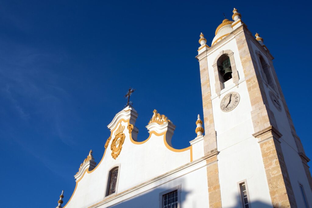 Traditional white church with high bell tower. View from below. Portimao, Algarve, Portugal. Stock Free