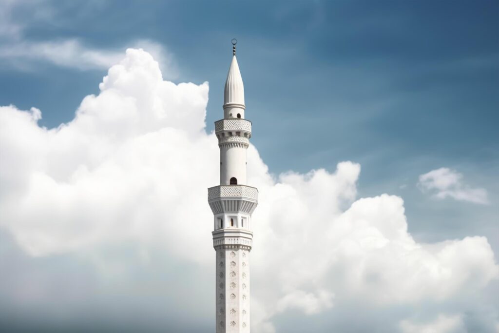 White mosque minaret. Mosque minaret with cloudy sky in background. Stock Free