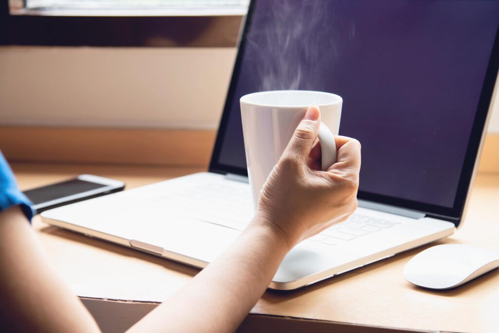 Woman working with computer with coffee cup in the hotel room – people working lifestyle concept Stock Free