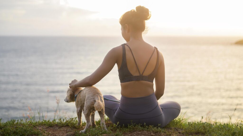 Young Beautiful woman with her dog enjoying and relaxing on the seaside during sunset, Summer, vacation, holidays, Lifestyles concept. Stock Free