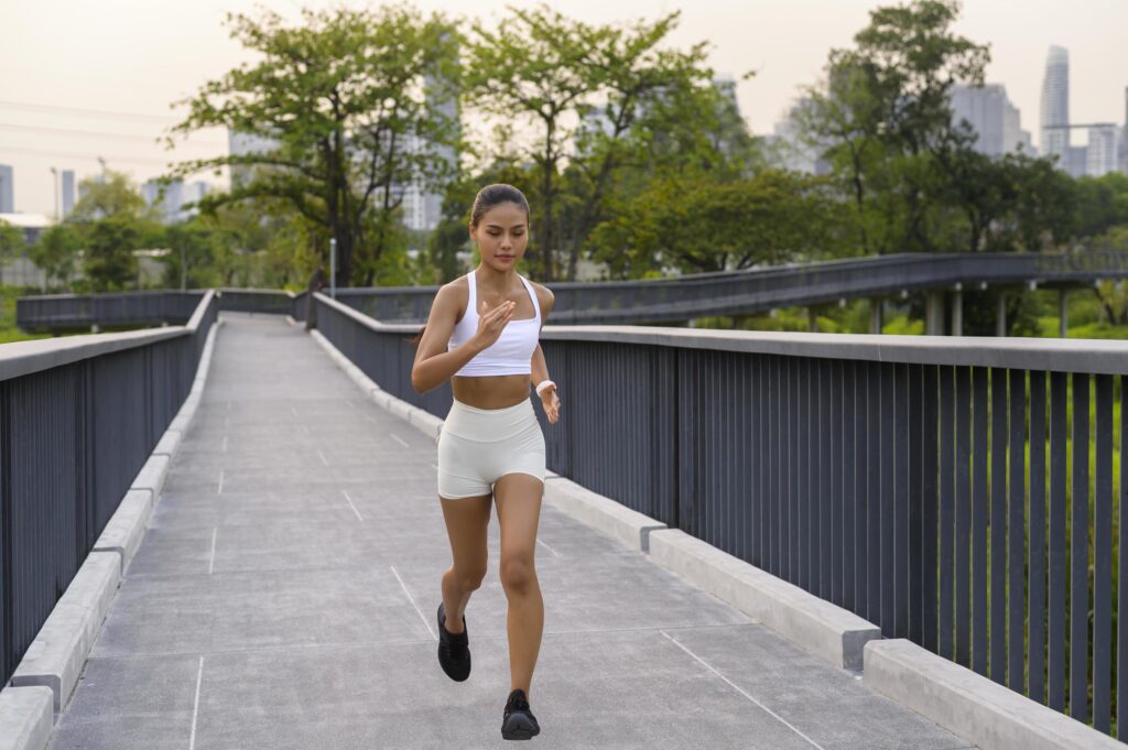 Young fitness woman in sportswear jogging in city park, Healthy and Lifestyles. Stock Free