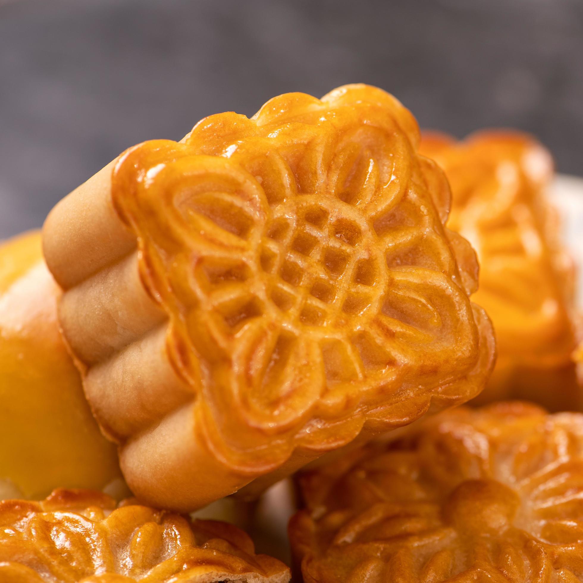 Tasty baked egg yolk pastry moon cake for Mid-Autumn Festival on black slate dark background. Chinese festive food concept, close up, copy space. Stock Free