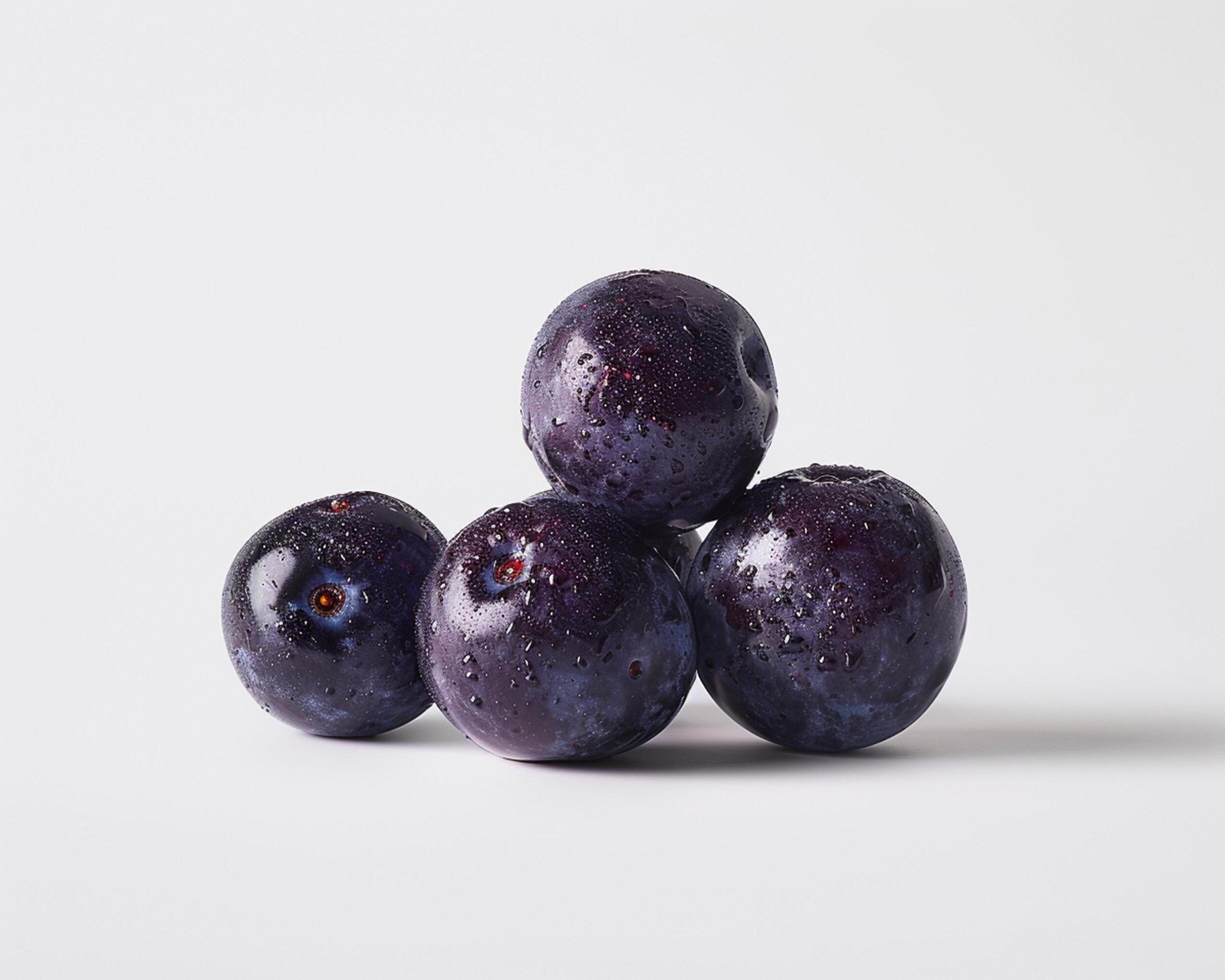 three blueberries are arranged on a white surface Stock Free