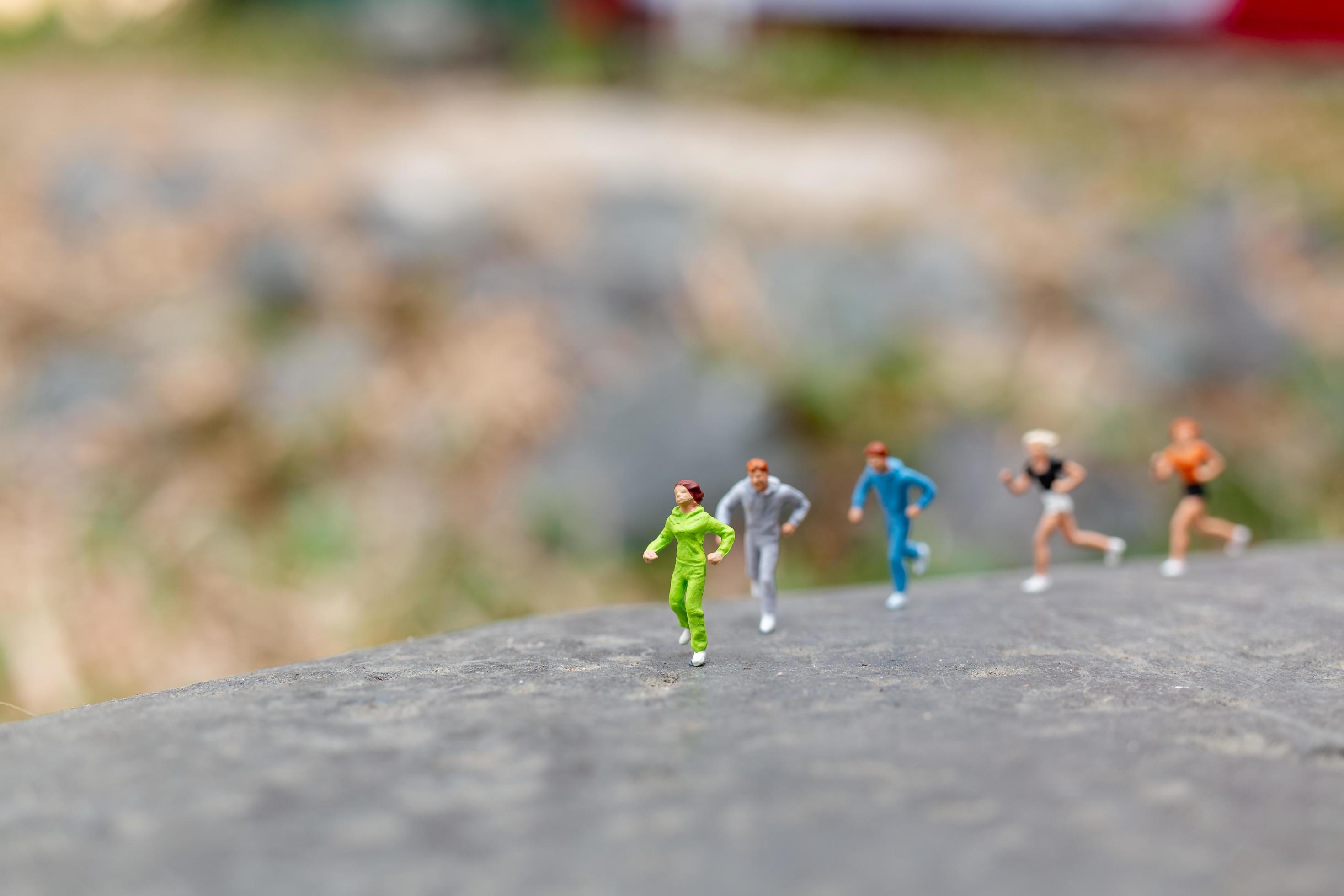 Miniature people running on a rock, health and lifestyle concept Stock Free