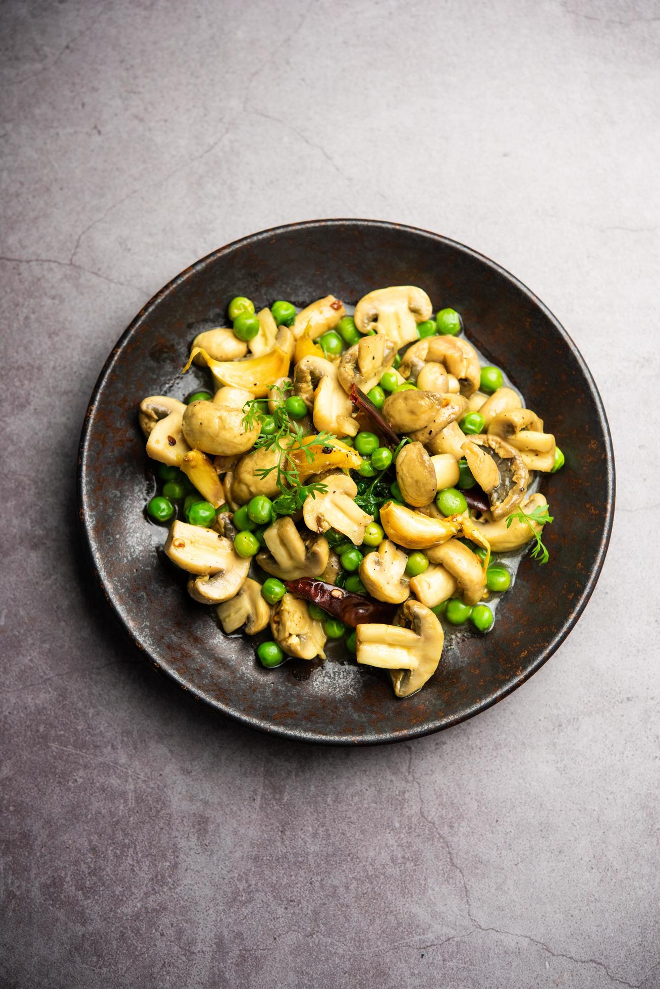 Mushroom and Pea Curry with Roasted Garlic, Indian food served in a bowl Stock Free