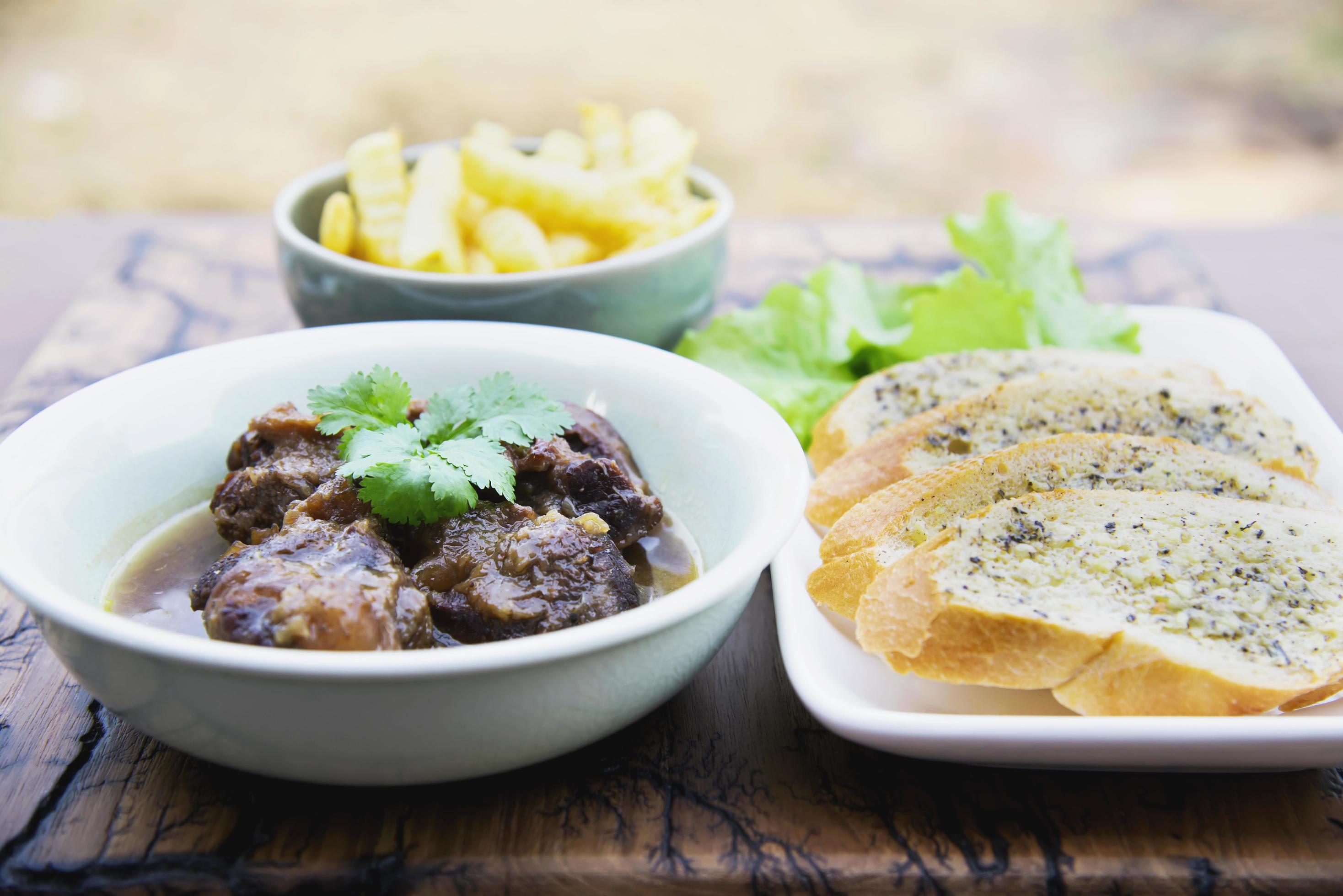 Beef and pork stew with French fries and others food recipes on wooden table, food meal preparing ready for eat concept Stock Free