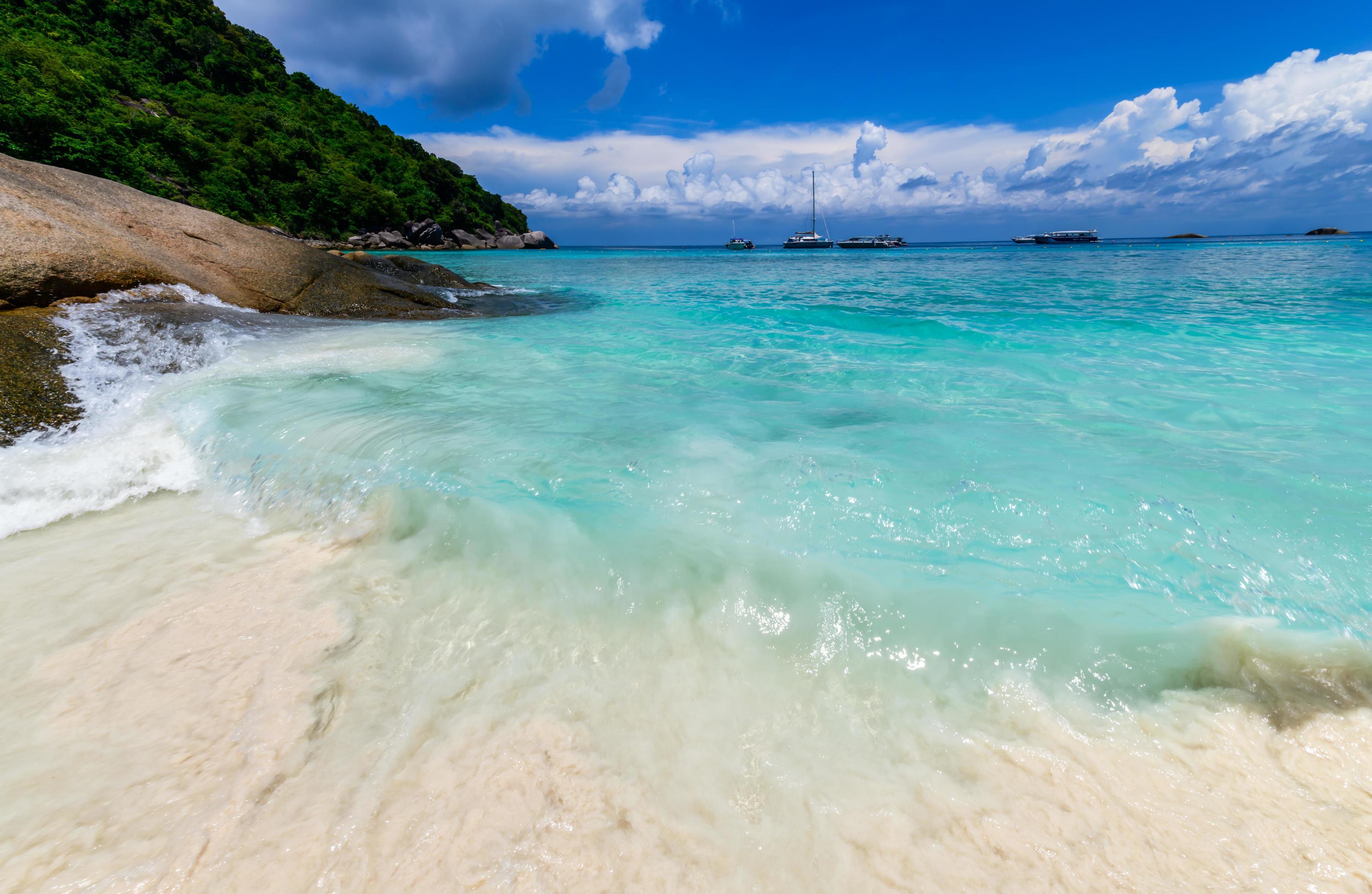 Movement of fine white sand with clear sea with white cloudy and blue sky at Similan Island, Stock Free