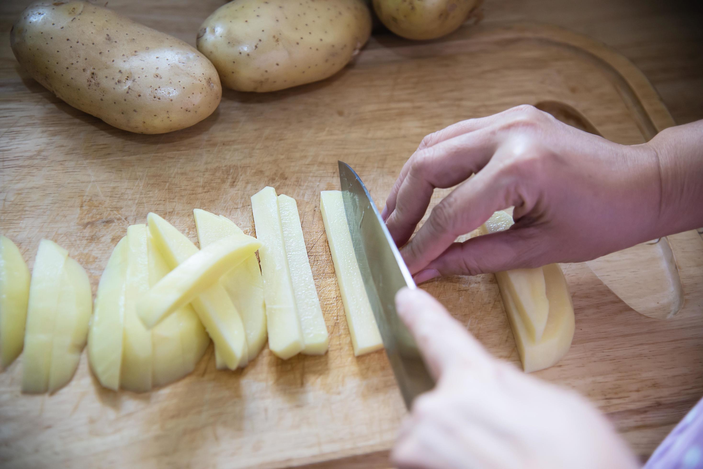 People cooking fresh potato preparing food in the kitchen – potato cooking concept Stock Free